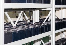 Rows of industrial batteries connected with cables in a storage facility