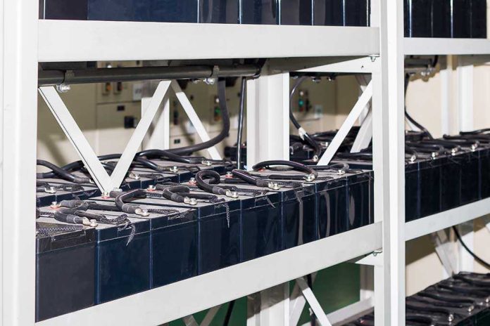 shutterstock_639542290.jpg Rows of industrial batteries connected with cables in a storage facility