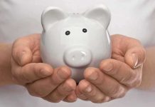 Hands holding a white ceramic piggy bank