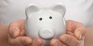 Hands holding a white ceramic piggy bank
