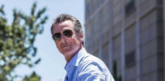 Man in sunglasses wearing a blue button-up shirt.