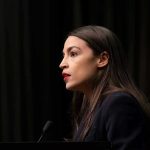 Person speaking at a podium side profile view