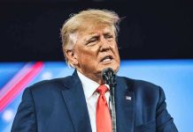 Trump Loyalist TURN – SLAMS President! Man in suit speaking at a microphone.