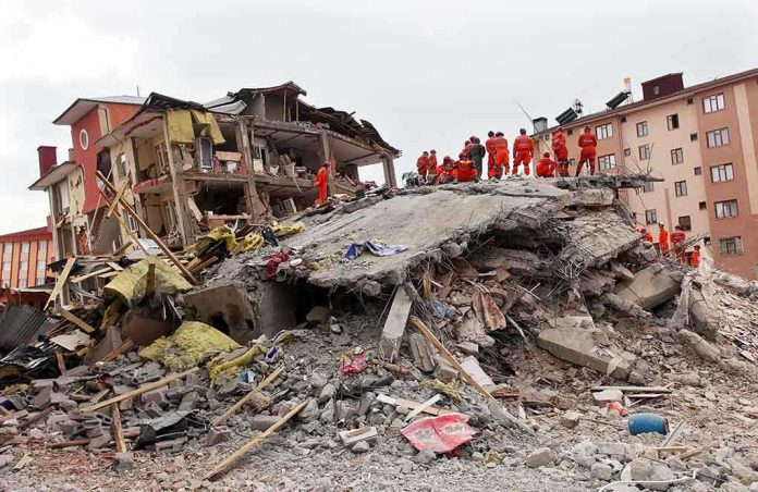 shutterstock_148947701.jpg Rescue workers in orange uniforms on a collapsed building site after an earthquake