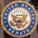 Senator Under SIEGE From Own Party – They Want Him Out! Sign displaying United States Senate in a government building