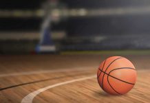 NBA Coach ARRESTED – Corruption Scheme! A basketball on a wooden court