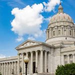 Large white government building with a dome.