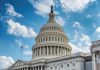 Washington Under SIEGE – 500 Troops Deployed U.S. Capitol building dome under clear blue sky.