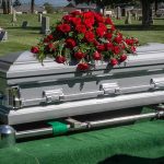 LEGEND DIES – Global Music Icon Gone Silver casket with red roses in a cemetery.
