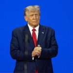 Trump Pardon BACKFIRES – He Offended AGAIN! Man in a suit with a blue background.