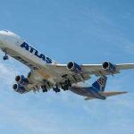 Airplane with Atlas logo flying in the sky.
