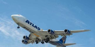 Airplane with Atlas logo flying in the sky.