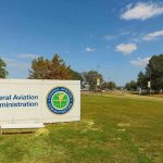 Controllers ISSUE WARNING — Aviation CHAOS IMMINENT! Federal Aviation Administration sign on grassy lawn.