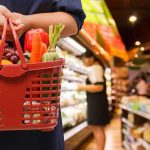 Grocery Chains Bold Move Sparks ICE Controversy Person holding a basket filled with colorful vegetables in a supermarket