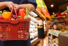 Grocery Chains Bold Move Sparks ICE Controversy Person holding a basket filled with colorful vegetables in a supermarket