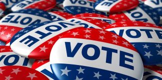A pile of colorful buttons with the word VOTE and stars, symbolizing election participation