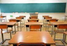 SHOCKING Child Abuse Charges Rock Tennessee School Empty classroom with desks and a chalkboard.