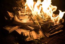 Ex-CIA Warns Dollar Doom Stacks of hundred dollar bills burning in flames.