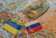 Putin’s Stalling Tactics Exposed – Ukrainian Suffers Toy tank on map with Ukraine and Russia flags.