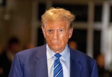 Trump Sanctions CRUSH Evasion Man in blue suit and striped tie, serious expression.