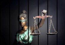 Corruption Scheme Exposes BROKEN Pardon System Blindfolded Lady Justice statue holding scales behind bars.