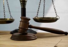 Gavel and scales of justice on wooden table.