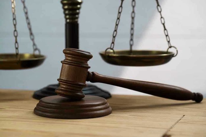Gavel and scales of justice on wooden table.