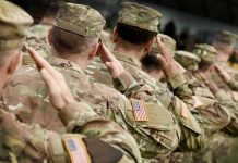 US Troops Land In Nigeria—NIGHTMARE Unfolding Soldiers in camouflage uniforms saluting in formation outdoors