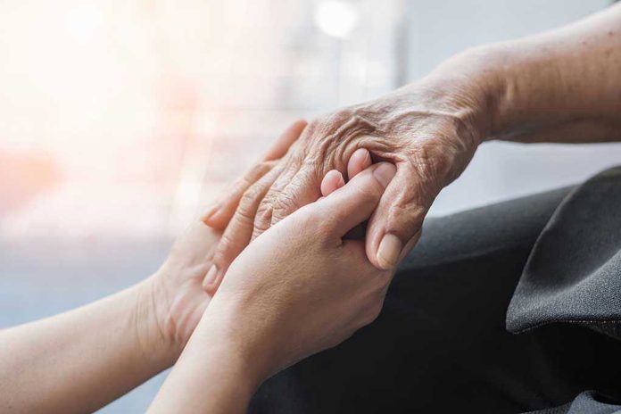 Young hands holding an elderly persons hand.