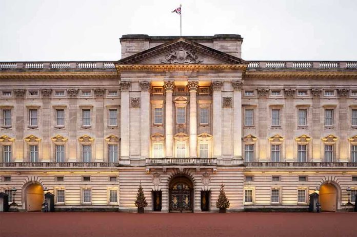 Front view of Buckingham Palace with illuminated facade and British flag