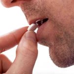 BREAKTHROUGH Hormone-Free Male Pill Hits Trials Close-up of a man preparing to take a pill