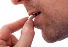 Close-up of a man preparing to take a pill