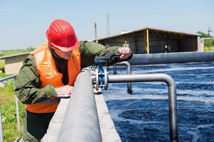 shutterstock_197223314.jpg Worker in safety gear inspecting water treatment equipment