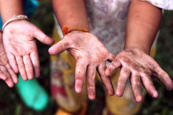 Two childrens hands raised, showing dirt and grime from outdoor play