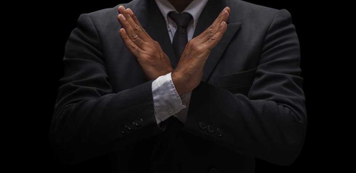 shutterstock_645990331.jpg A man in a suit crossing his arms in a gesture of refusal or rejection