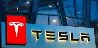 Tesla logo on a building at night.