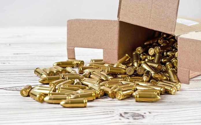 Box of brass bullets spilled on wooden surface.