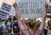 Abortion Numbers EXPLODE In Massachusetts Protestors holding signs about womens rights and healthcare.