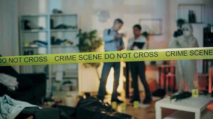 Crime scene with tape and investigators examining evidence.