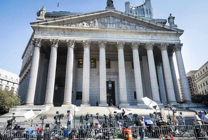 2445868619 Courthouse facade with media crews setting up outside.