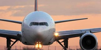 Airplane on runway during sunset.