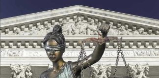 Lady Justice statue in front of courthouse.