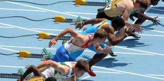 Athletes in starting position for a sprint race on a track
