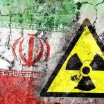 Iran Missiles SLAM Five U.S. Bases Simultaneously A cracked wall featuring the Iranian flag and a nuclear warning symbol