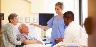 A nurse and a doctor discussing with a patient and his family in a hospital room