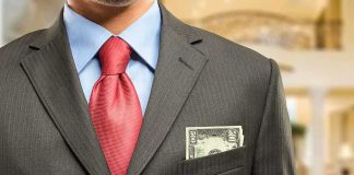 Man in a suit with a red tie and money peeking from his pocket