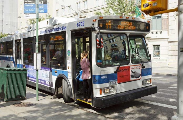 A woman boarding a clean air hybrid electric bus at a city stop