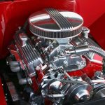 Close-up of a shiny chrome engine inside a red car