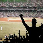 Crowd of fans cheering at a baseball game in a stadium