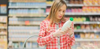 Woman examining a bottle in a grocery store